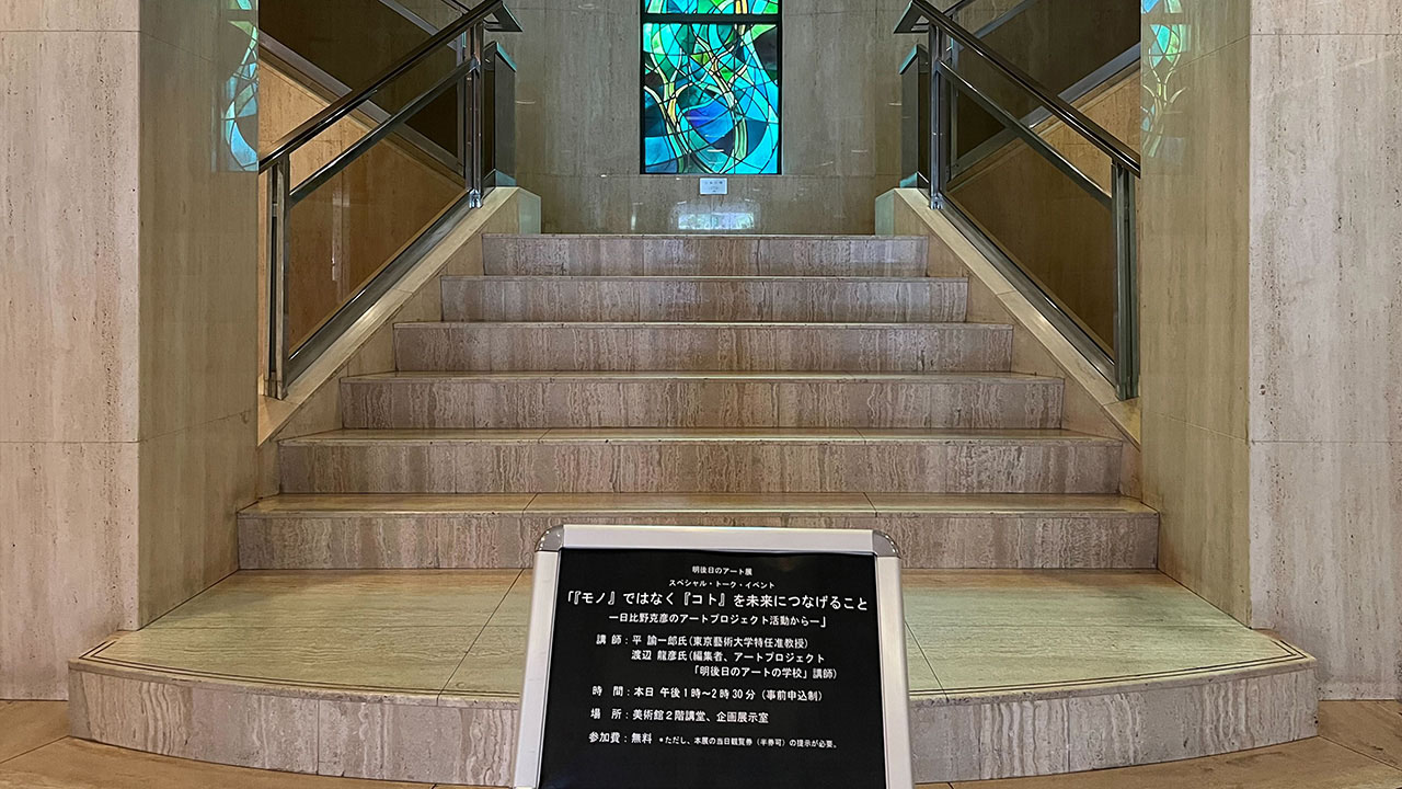 姫路市立美術館のエントランスに置かれた講演の案内。奥に見えるステインドグラスは立花江津子氏（立花晃幹事のお母様）の作品である。