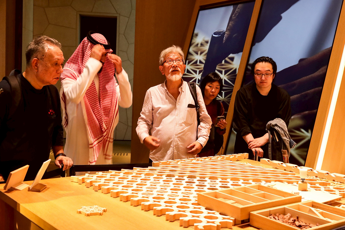 サウジ館職員（左から2人目）からマシュラビーヤについて説明を受ける三宅善信師（中央）、永原順子氏（奥）、月ヶ瀬悠次郎代表（右）／撮影：上田成昭幹事