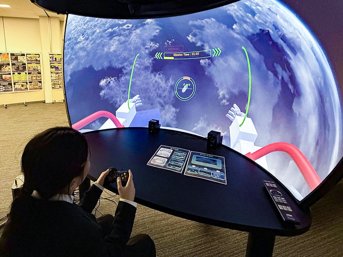 宇宙デブリの除去体験をしている参加者